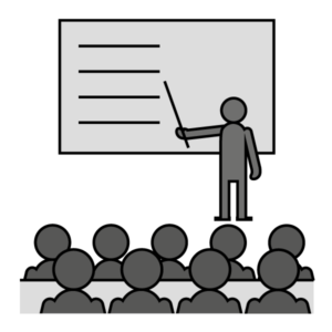 Mustavalkoinen piirroskuva, jossa hahmo seisoo karttakeppi kädessään yleisön edessä.
